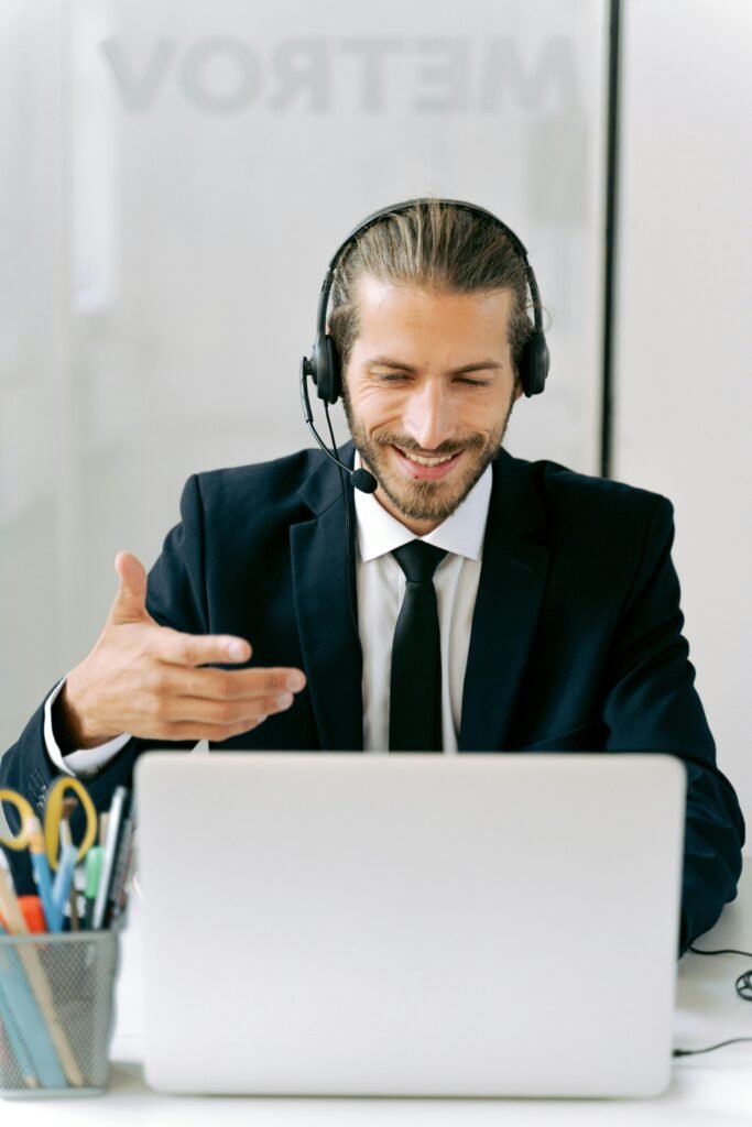 pexels-photo-5467596-5467596 Confident businessman in suit with headset conducting an online meeting from office.
